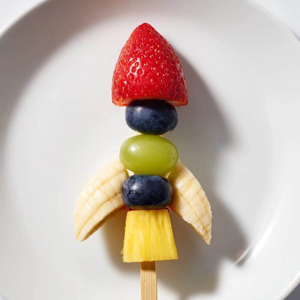 Vibrant Rocket Ship Fruit Skewers made with strawberries, pineapple, and grapes, a healthy snack idea.