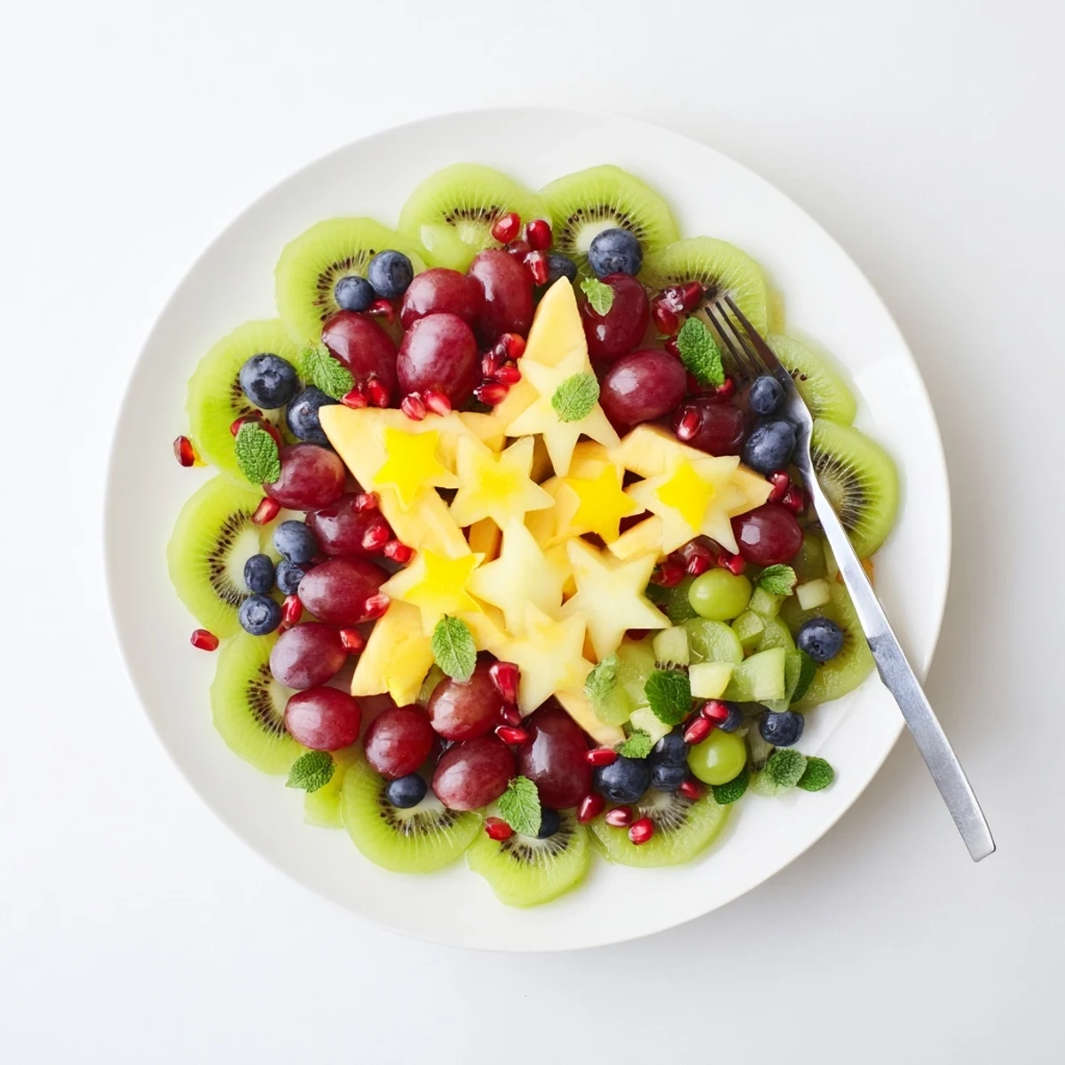 Vibrantly colored Pomegranate and Mint Star Fruit Platter with glistening, ruby-red pomegranate seeds and fresh mint.