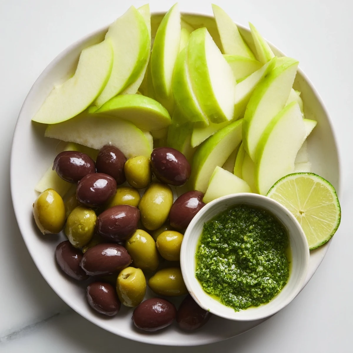 Green-themed appetizer: The Emerald City recipe with fresh limes, olives, and pesto beautifully arranged.