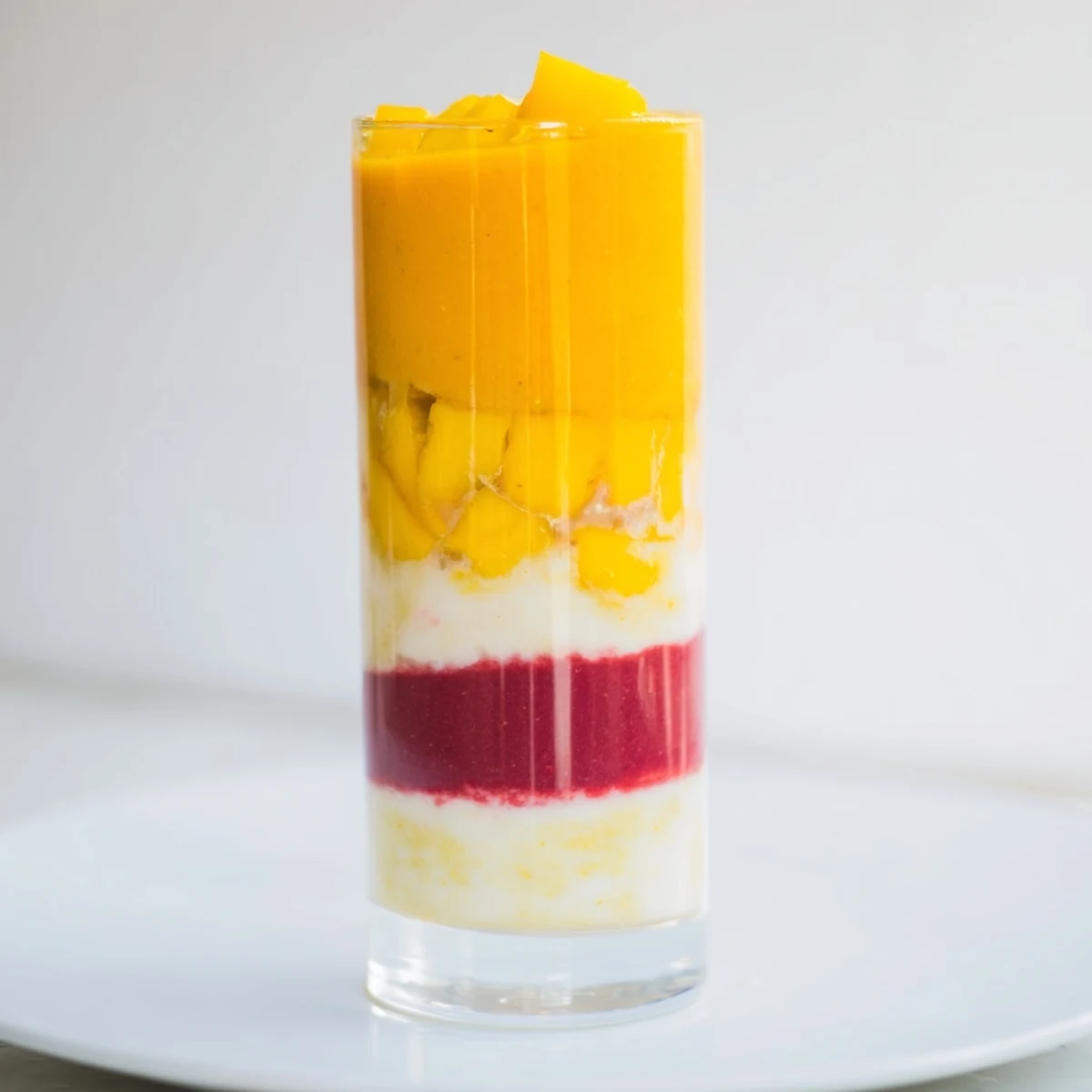 The colorful ombré effect of the Tropical Sunset Smoothie, ideal for a beautiful treat.