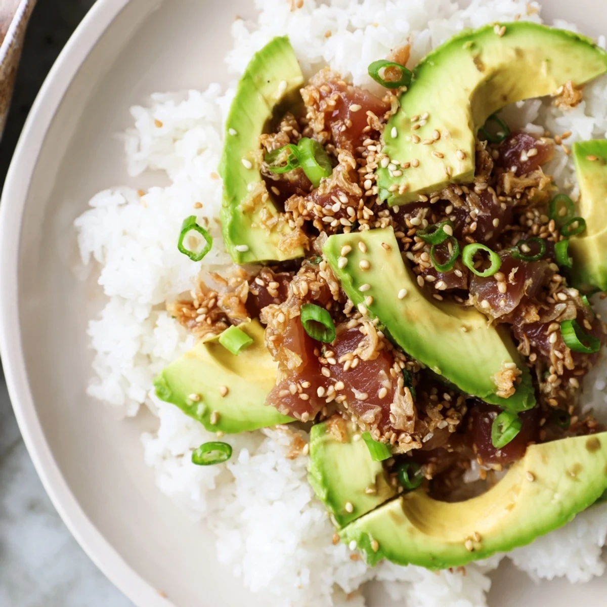This Tuna Avocado Rice Bowl is a beautifully layered meal, served in a bowl, perfect for a quick lunch.