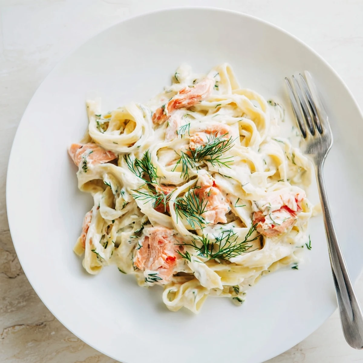 Pasta fettuccine con salmón ahumado ahumado, salsa cremosa de limón y eneldo fresco.