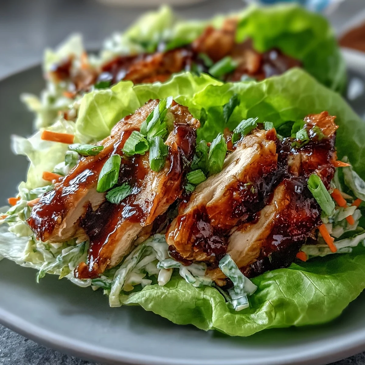 Envoltorios de lechuga con pollo BBQ alto en proteínas y ensalada crujiente, un plato saludable y portátil perfecto para la preparación de comidas.  