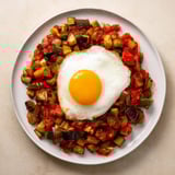 Hearty pisto with a fried egg; a flavorful Spanish vegetable dish perfect for a light supper.