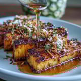 2. Rodajas de piña caramelizadas con glaseado de miel y lima, espolvoreadas con coco dorado y crujiente.  