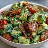 Ensalada colorida de pepino, tomate y aguacate con aderezo de limón picante.  