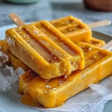 Paletas veganas de mango y coco listas para disfrutar, un postre sin lácteos ideal.