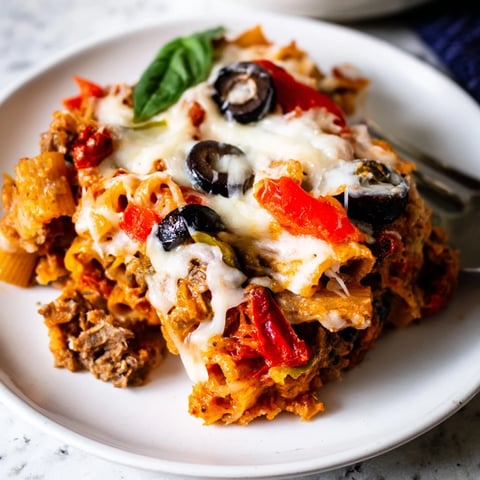 Pasta al horno con aceitunas y tomates secos, cremosa y dorada al disfrutar.