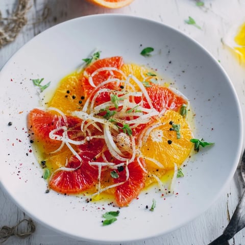 Ensalada española de naranja y aceite de oliva, irradia frescura con rodajas de naranja y aceitunas.  