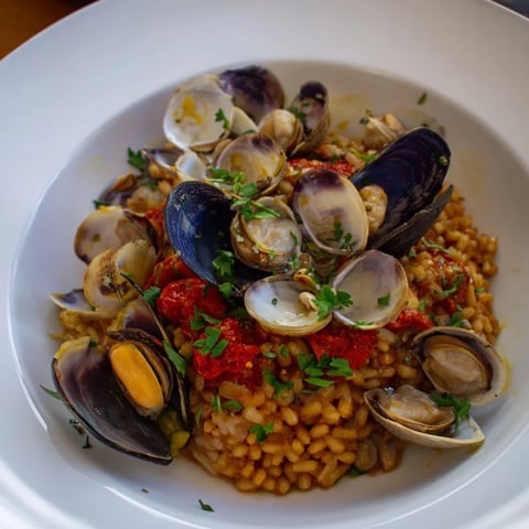 Arroz con Mussels and Cherries, a colorful dish with steamed mussels and vibrant cherries.