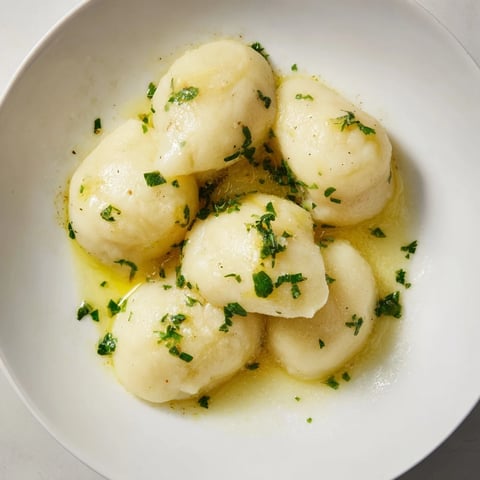 Fluffy potato dumplings drizzled with truffle oil, perfectly golden and waiting to be served for a savory meal.
