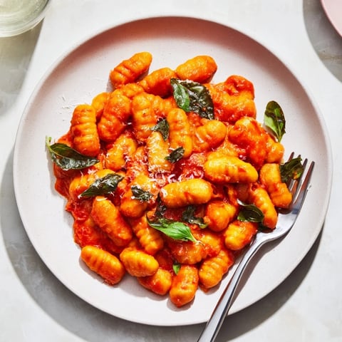 Plump, homemade potato gnocchi swimming in a vibrant, fresh tomato sauce, ready to eat.