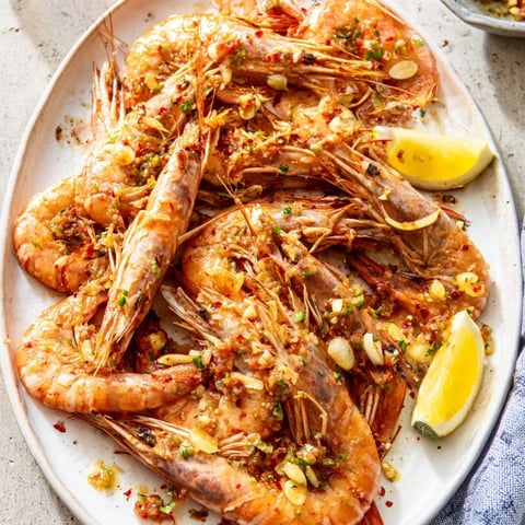 Sizzling lightened Gambas al Ajillo with plump shrimp, swimming in garlic-infused olive oil, ready to serve.
