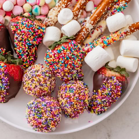 A vibrant Rainbow Sprinkle Party Board, overflowing with colorful, sprinkle-covered treats for a joyous party.