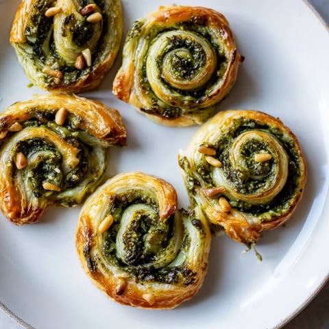Golden, star-shaped pesto pinwheels, ready to eat, offer a delightful mix of flavors and textures.