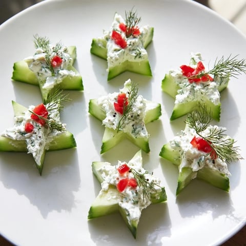 Crisp cucumber and dill Christmas stars appetizer, topped with creamy cheese, ready to serve.