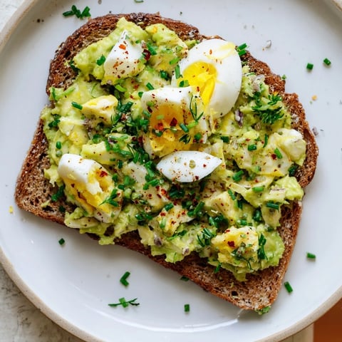 Creamy avocado egg smash on toasted bread, a vibrant and flavorful breakfast ready to enjoy.