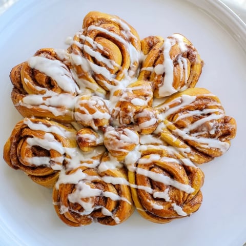 Cinnamon Roll Pull-Apart Snowflake: A golden-baked festive treat, ready to be pulled apart and shared, iced with vanilla.
