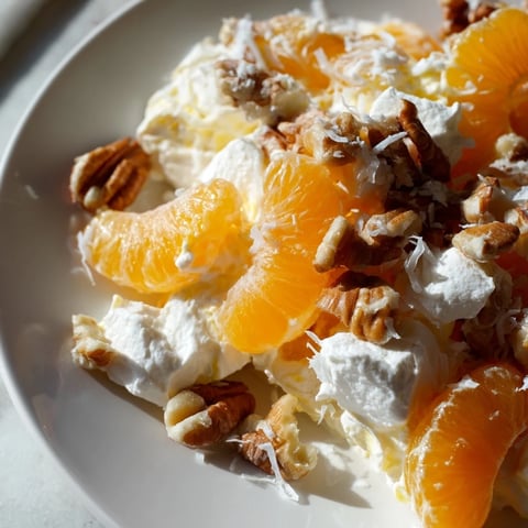 Luxurious Elevated Ambrosia Salad, showcasing mandarin oranges, pecans, and bourbon-infused whipped cream, ready to serve.