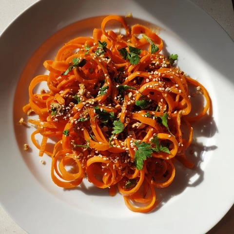 A photo shows a vibrant Carrot Ribbon Salad Asian-Style, with crunchy sesame seeds.