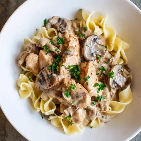Creamy Chicken and Mushroom Stroganoff served over buttery egg noodles, a comforting classic.