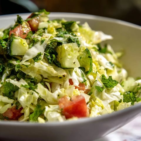 Ensalada libanesa con repollo crujiente, perejil fresco y un aderezo de limón que resalta su sabor vibrante.