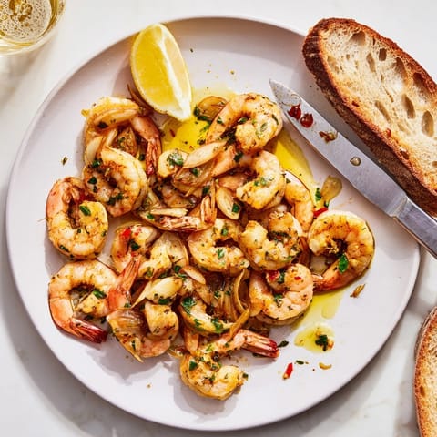 Sartén de camarones al ajillo: camarones jugosos en aceite de ajo con perejil fresco.