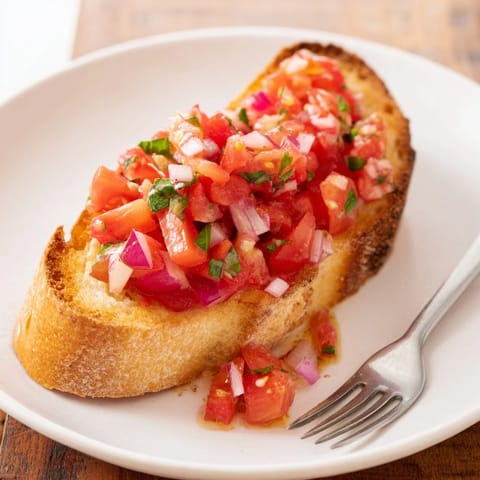 Deliciosa receta de pan rústico con salsa de tomate, perfecta para un aperitivo soleado.