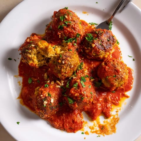Albóndigas de garbanzos hechas en casa, bañadas en salsa romesco ahumada, listas para servir.