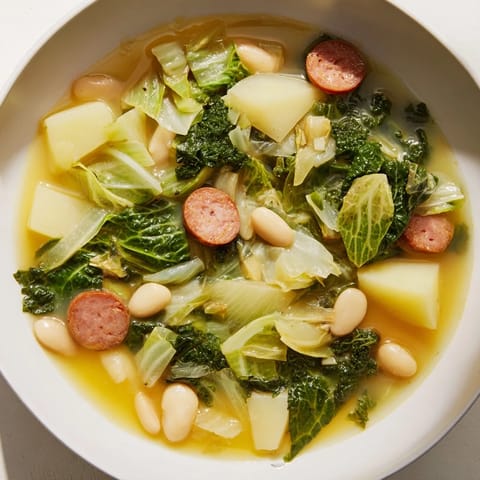 This minimalist Caldo Gallego Moderno features vibrant greens, beans, and chorizo in a clear broth.