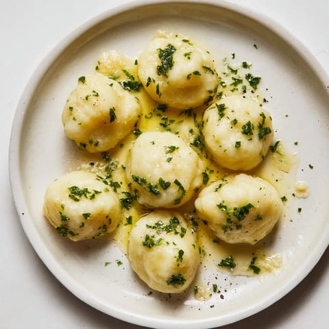 A close-up shot of homemade potato dumplings, showcasing the tender texture and aromatic truffle oil drizzle.