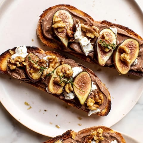 Elegant Royal Tapestry appetizer: layers of pâté, figs, and goat cheese on toasted brioche, ready to serve.