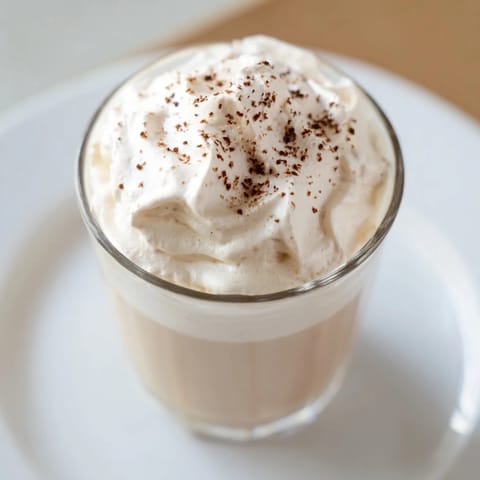 A close-up view of a homemade Whipped Dalgona Coffee, showing the creamy texture and sweet drink.