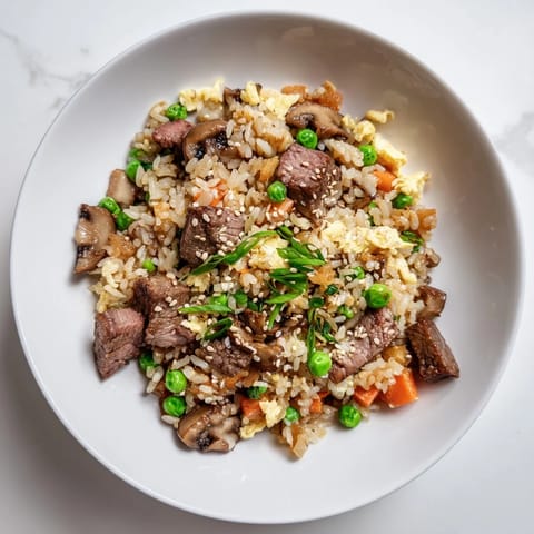 Easy Hibachi Steak With Fried Rice en un wok humeante, con bistec, vegetales crujientes y cebolletas verdes, servido para una cena casera rápida.