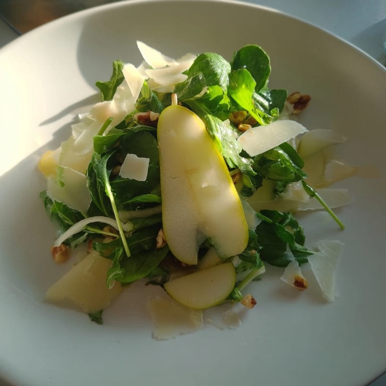 Vista cenital de la vibrante ensalada de peras y manchego otoñal, lista para un almuerzo ligero.