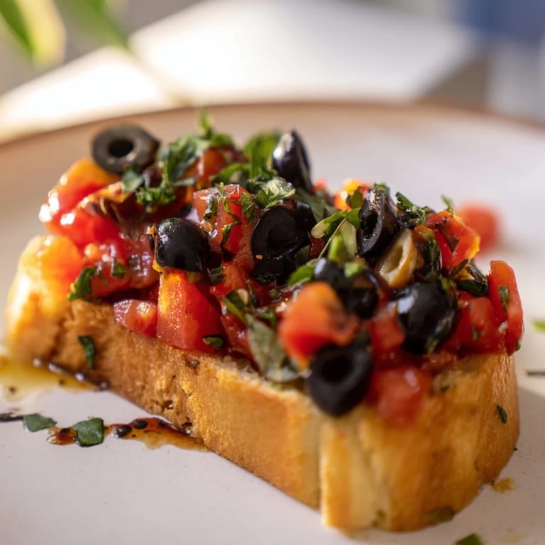 Deliciosa bruschetta con tomates jugosos, aceitunas y hierbas en pan dorado.  
