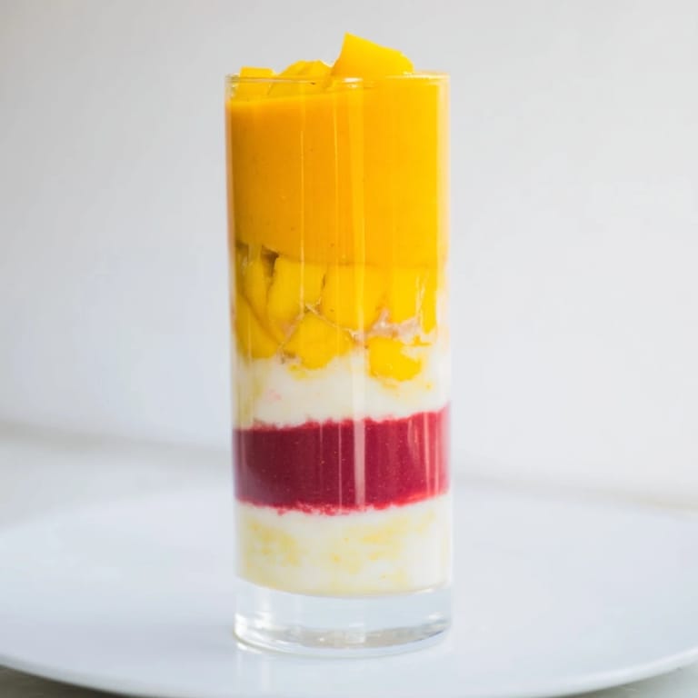 The colorful ombré effect of the Tropical Sunset Smoothie, ideal for a beautiful treat.