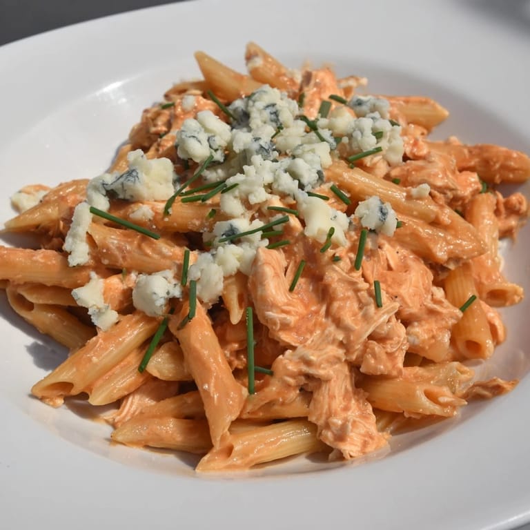 A satisfying bowl of Buffalo Chicken Pasta, showing tender chicken and penne coated in spicy sauce.