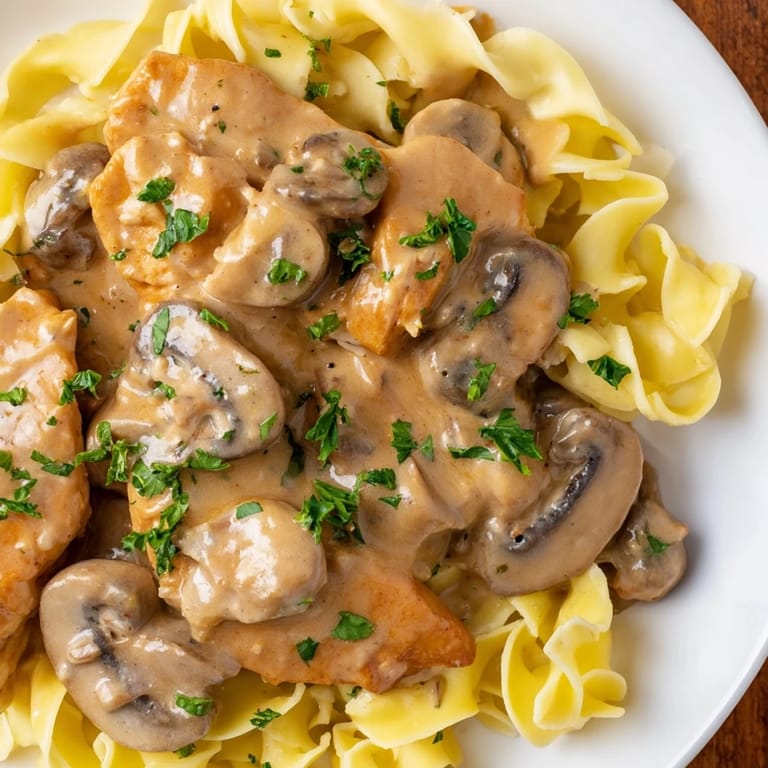 Warm Chicken and Mushroom Stroganoff with fresh parsley, a delicious family dinner idea.