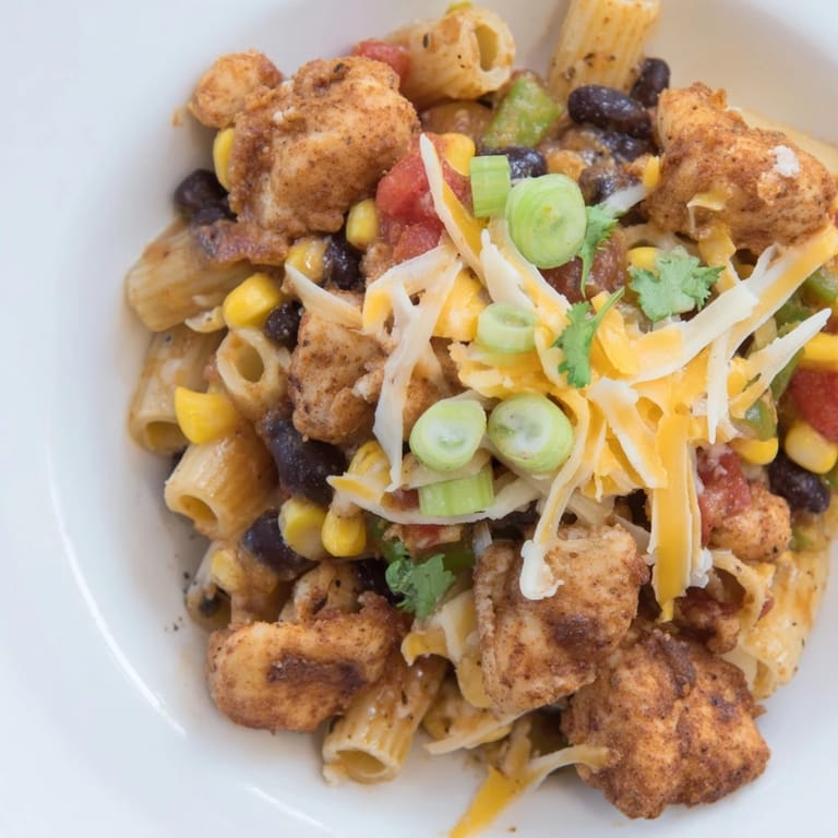 Close-up of a bubbling Crispy Chicken Burrito Pasta, showcasing tender chicken and creamy cheese.