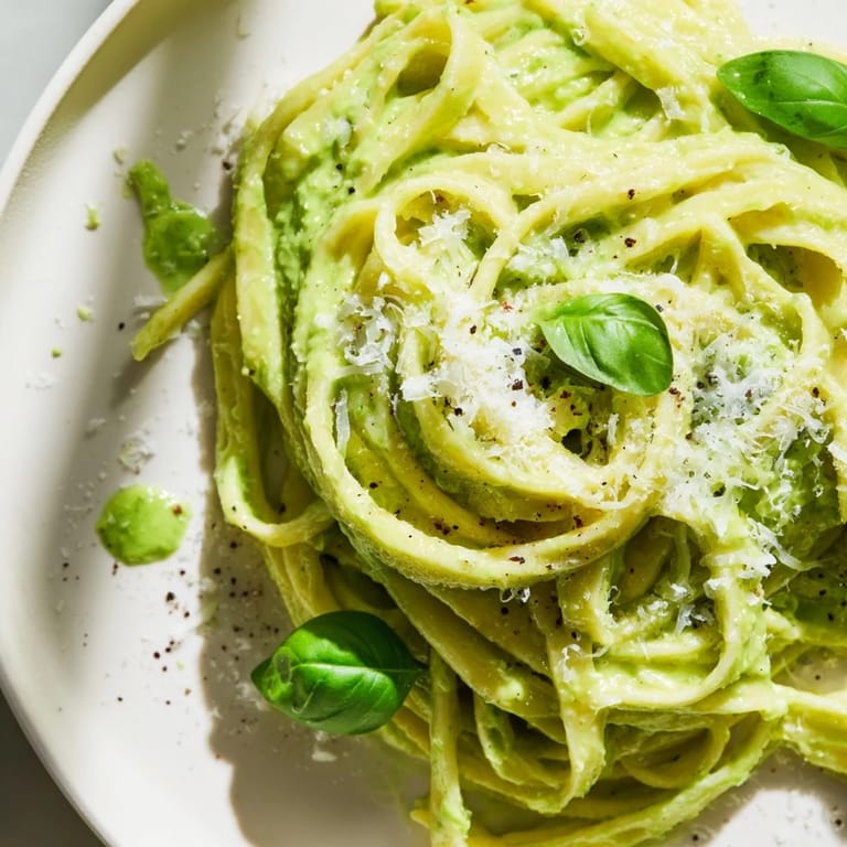 A close-up of Creamy Green Pea Alfredo, showcasing the pasta coated in rich, green sauce.