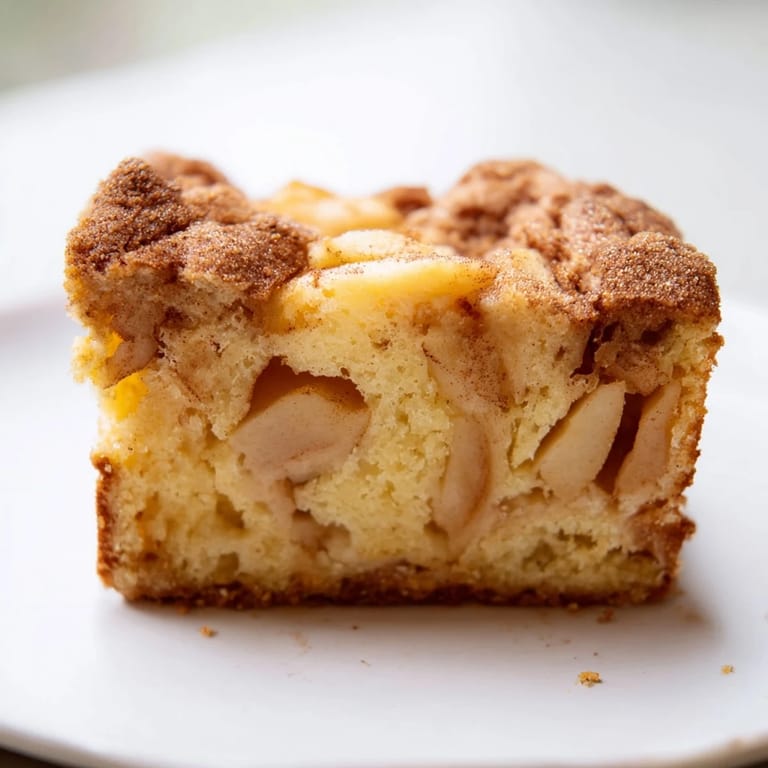 Homemade Baked Apple Cake cooling on a wire rack, dusted with powdered sugar and ready for a cozy breakfast.