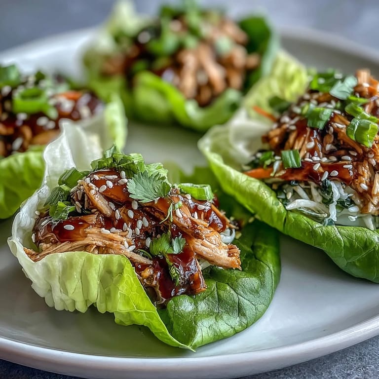 Sizzling Potsticker Noodle Lettuce Cups served warm with shredded carrots and cabbage, scallions, and herbs, perfect for an easy dinner.