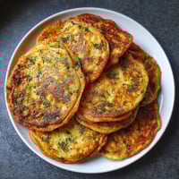 Plate of food with a green topping.