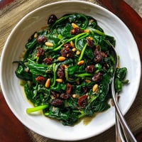 Plato de espinacas con nueces y pasas.