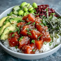 Foto de un vibrante bol de salmón poke con edamame cremoso y aguacate.
