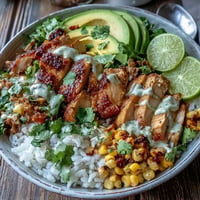 Tiernos cubos de pollo especiado coronan vibrantes Street Corn Chicken Rice Bowls.